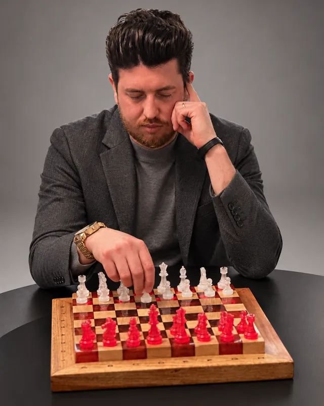 Júnior jogando num tabuleiro de xadrez de madeira e resina